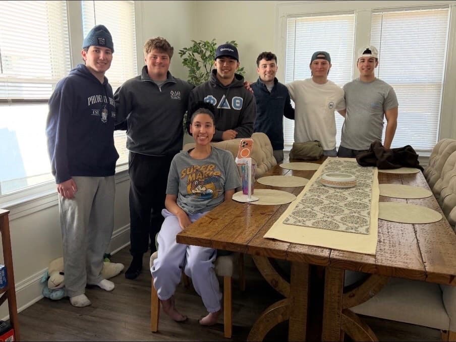 Phi Delta Theta brothers visiting and supporting a member of the local community