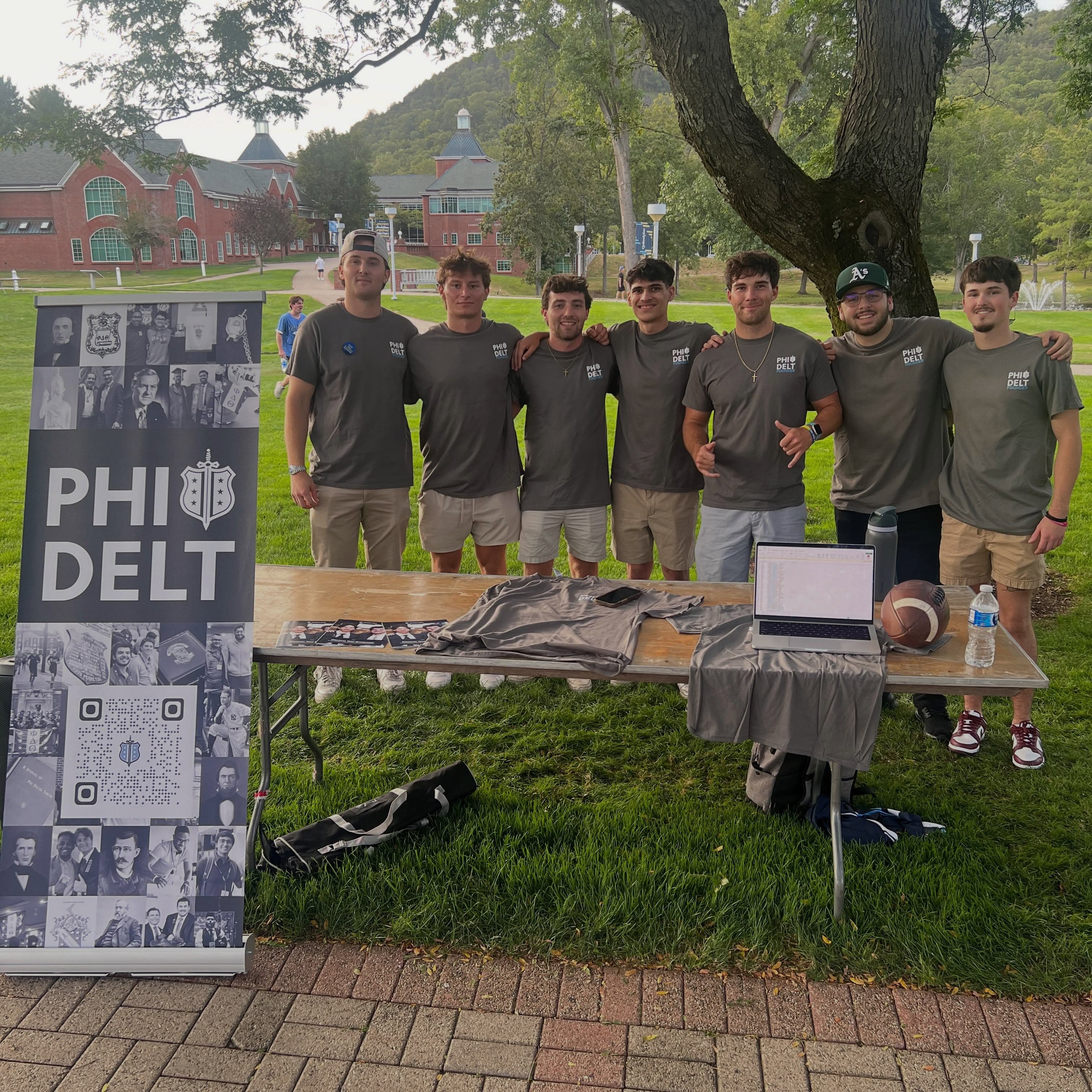 Phi Delta Theta brothers welcoming students at a campus table